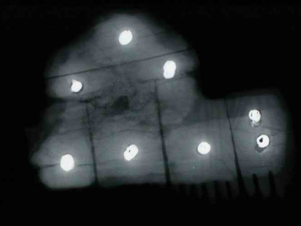 Rentgenový snímek kostěného hřebenu s bronzovými nýtky.