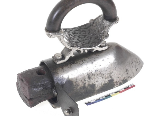 Krejčovská žehlička s vkládaným nahřívacím kovovým jádrem z druhé poloviny 19. století. Stav po konzervaci zviditelňuje povrchovou úpravu niklováním.