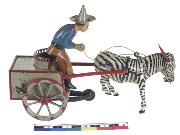 Plechová hračka z první čtvrtiny 20. století – jezdec s vozíkem.