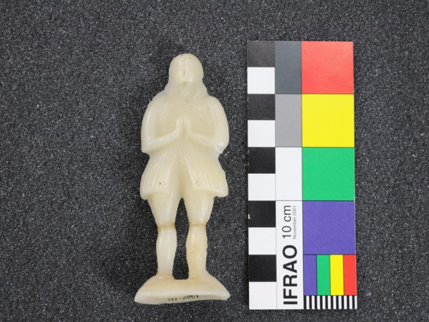 Obětina ve tvaru mužské postavy. Vosk, 19. stol. Po zásahu.